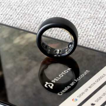 An Oura Ring 3 rests on a smartphone with the Peloton app displayed.